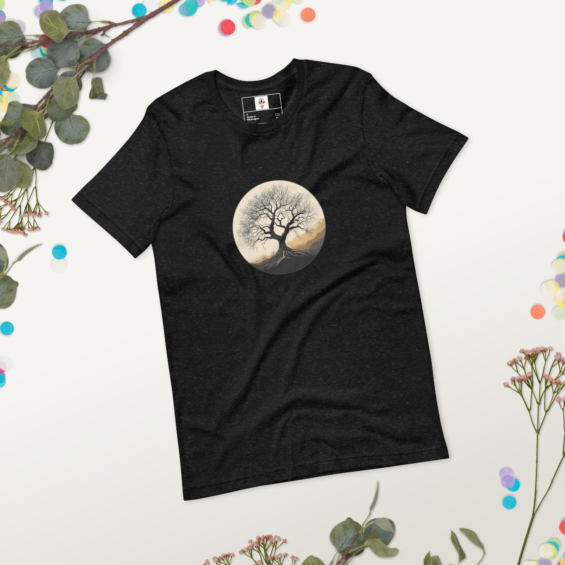 Roots of Life - Silhouette illustration of a bare tree with extensive roots, enclosed within a circle, featuring earthy tones and gentle mountains in the background. Graphic printed on black-heather-colored Unisex Staple T-Shirt Bella + Canvas 3001