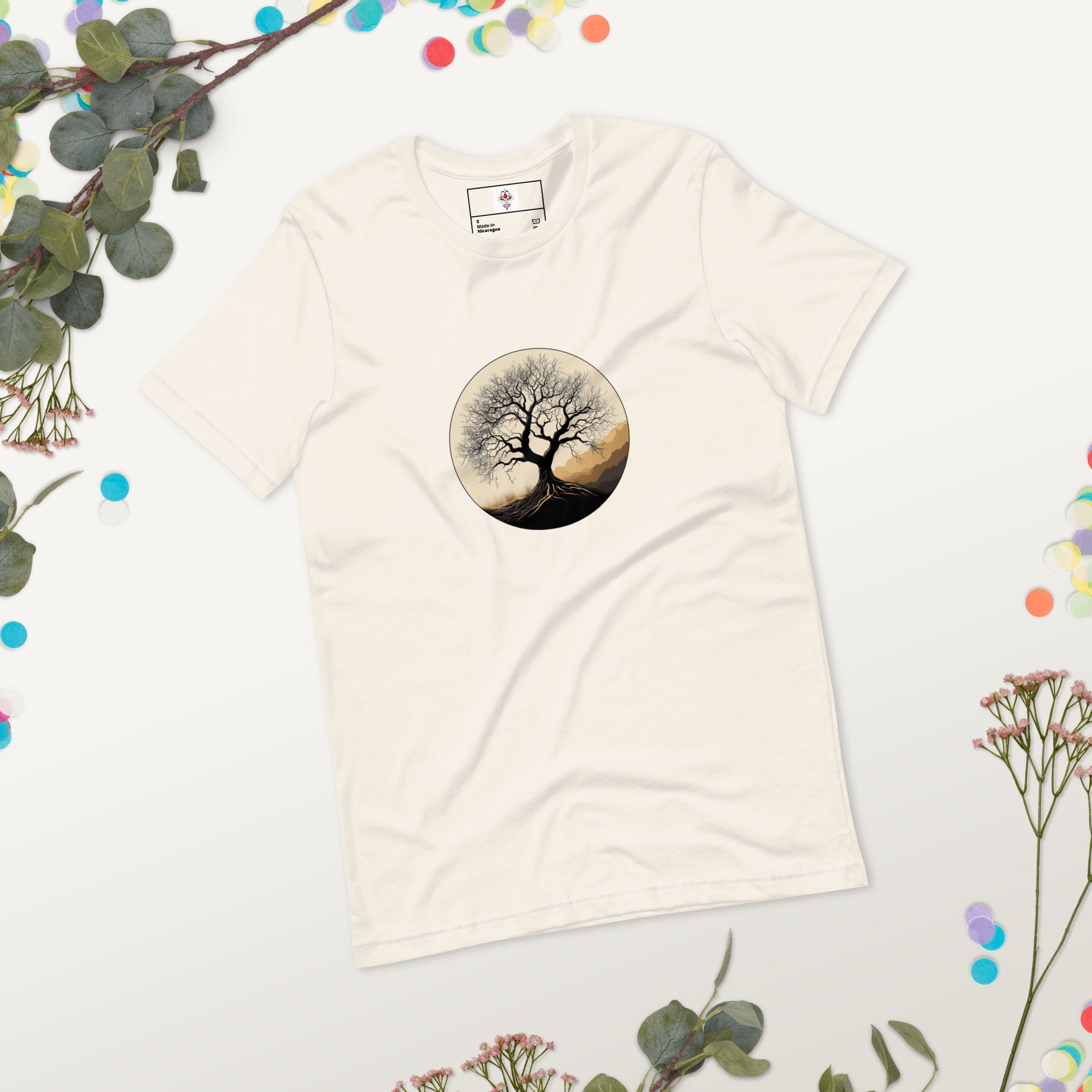 Roots of Life - Silhouette illustration of a bare tree with extensive roots, enclosed within a circle, featuring earthy tones and gentle mountains in the background. Graphic printed on vintage-white-colored Unisex Staple T-Shirt Bella + Canvas 3001